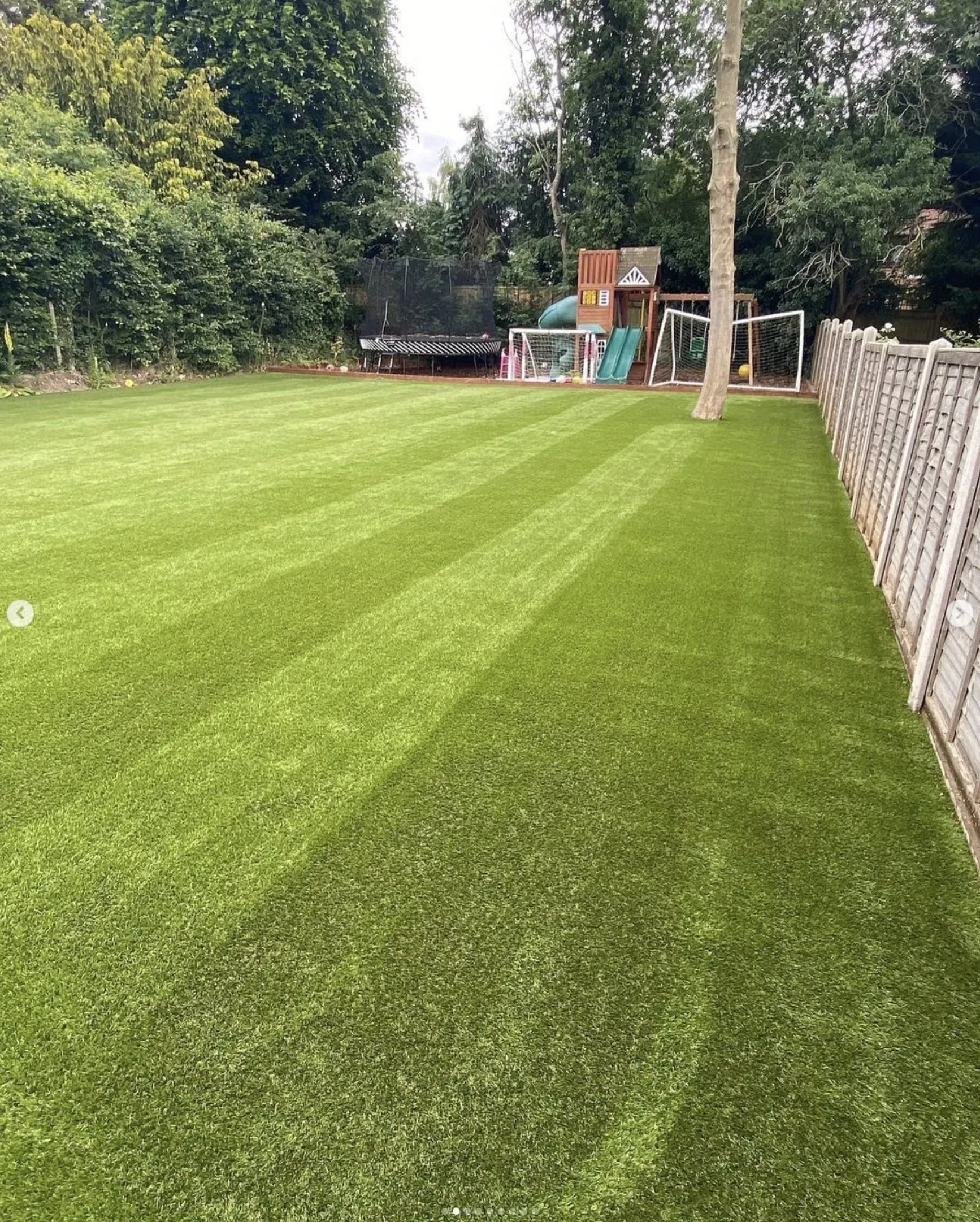 Large striped artificial lawn with a play frame and goals at the far end